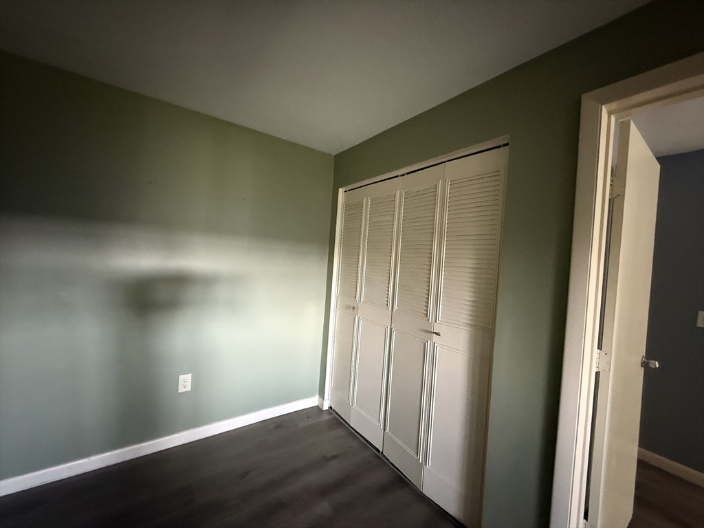 12 Williamsburg Court, Unit 2 Shrewsbury, MA 01545 - Photo 10 of 36 an empty room with wooden floor and windows