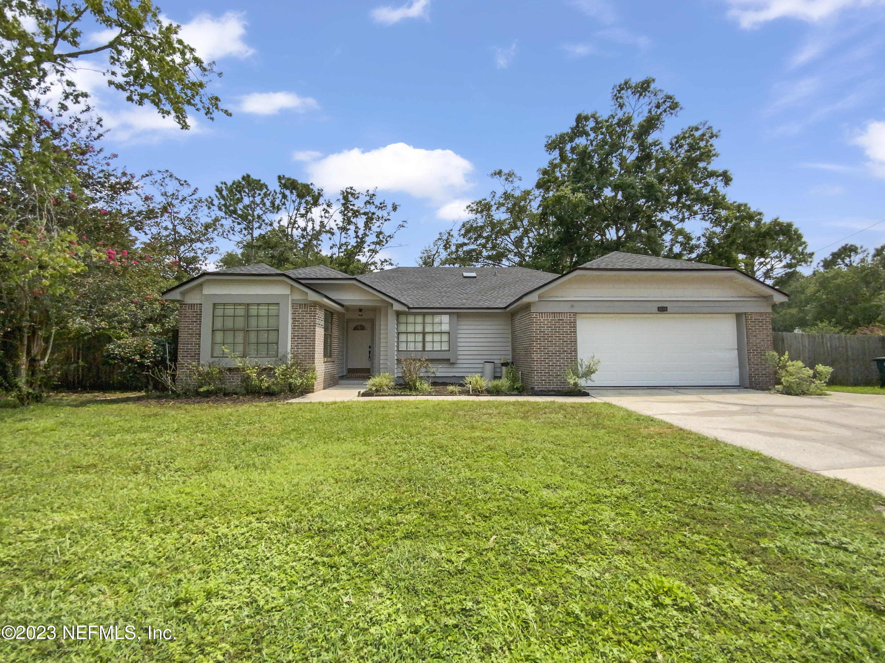 a front view of house with yard and trees