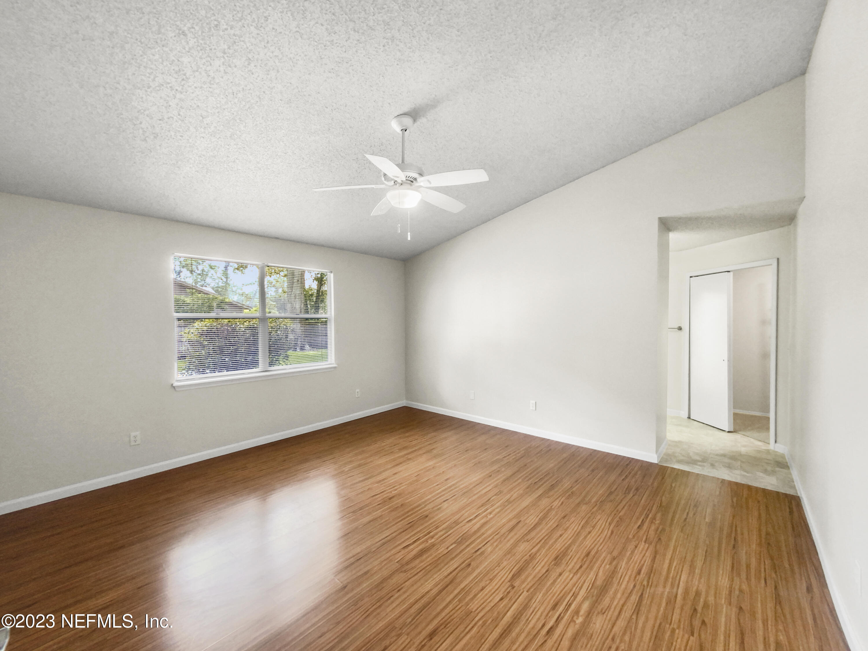 3550 Loretto Road Jacksonville, FL 32223 - Photo 3 of 19 an empty room with wooden floor chandelier fan and windows
