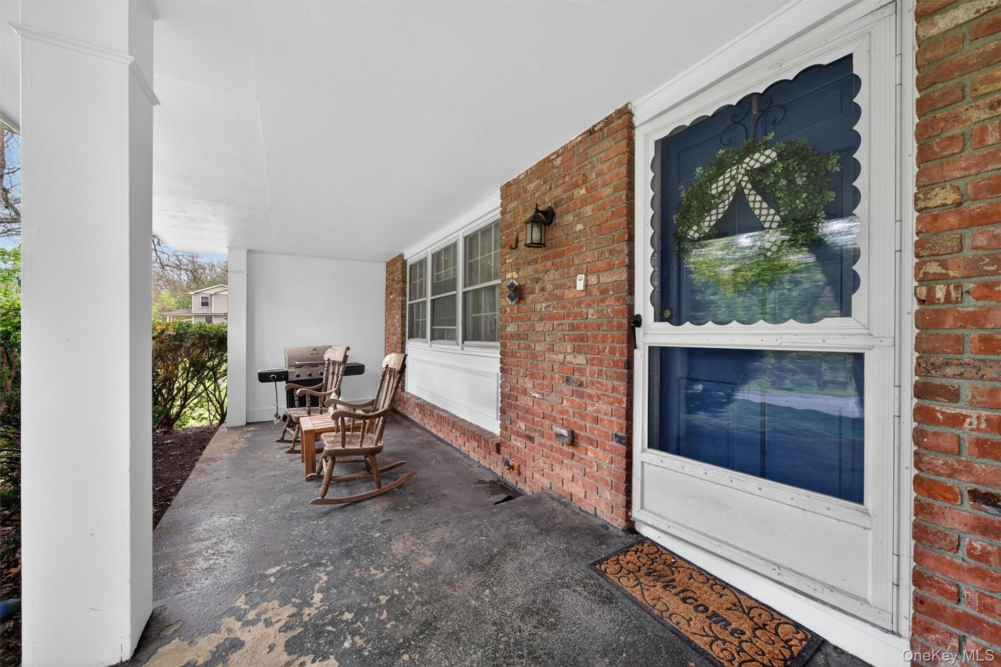 63 Hubshop Road Chester, NY 10918 - Photo 4 of 45 Covered porch featuring a brick facade, white support columns, and a concrete floor