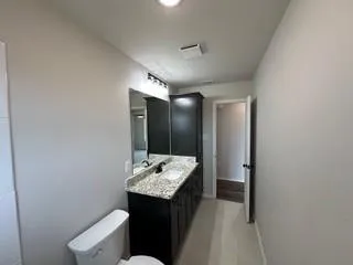 a bathroom with a sink toilet and mirror