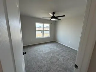 an empty room with windows and fan