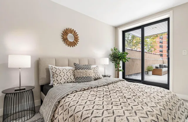 a bedroom with a large bed and a potted plant