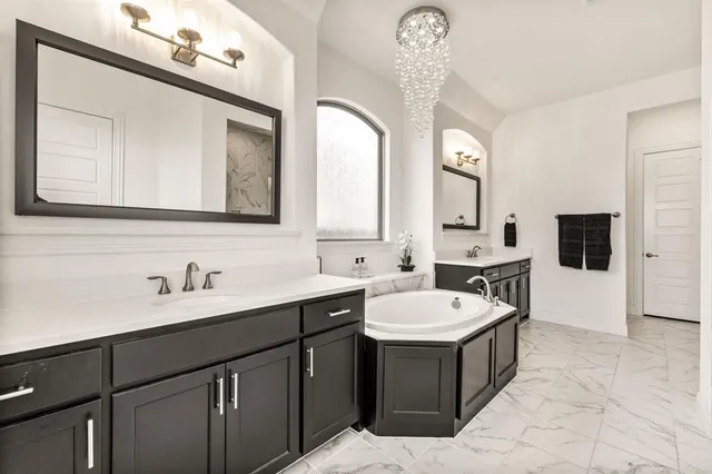 a bathroom with a double vanity sink a mirror and a bathtub