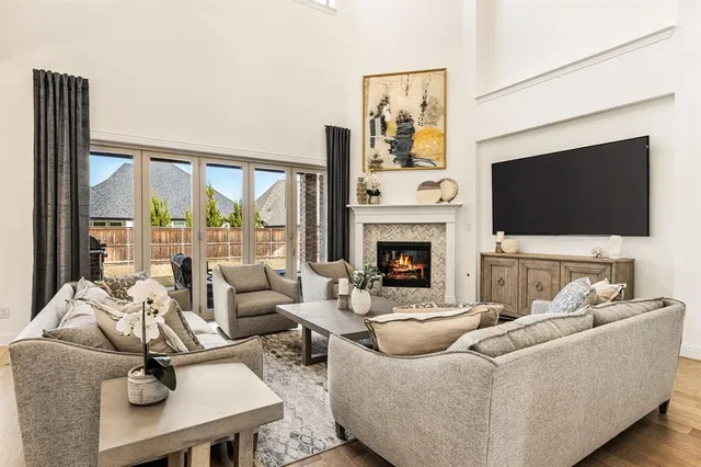 a living room with furniture a flat screen tv and a fireplace