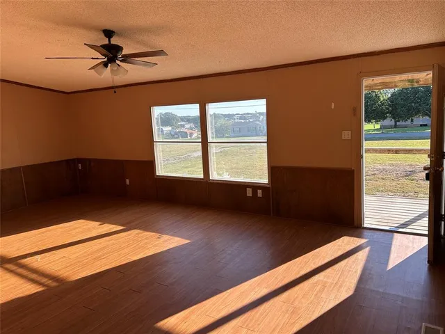 a view of a room with wooden floor and a ceiling fan