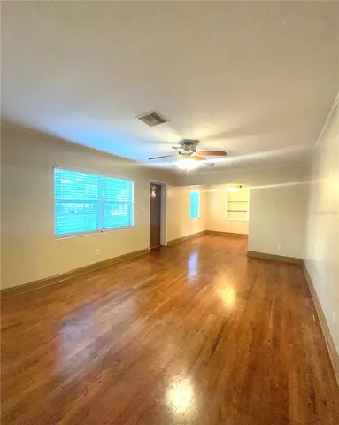 a view of empty room with wooden floor