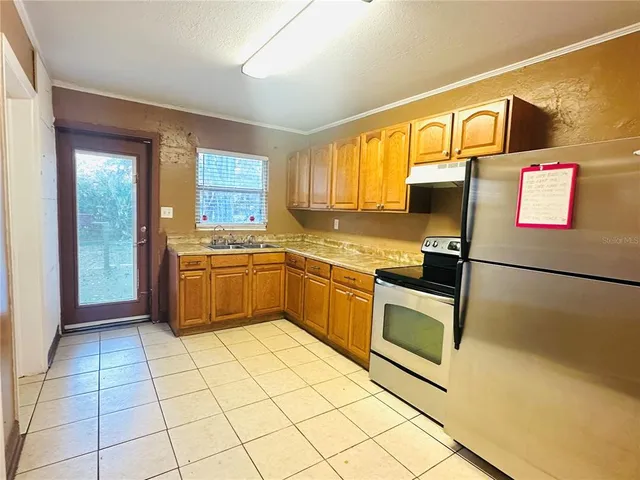 a kitchen with stainless steel appliances granite countertop a stove a sink and a refrigerator