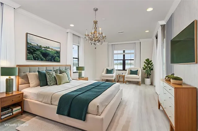 a bedroom with a large bed a flat screen tv and a couch