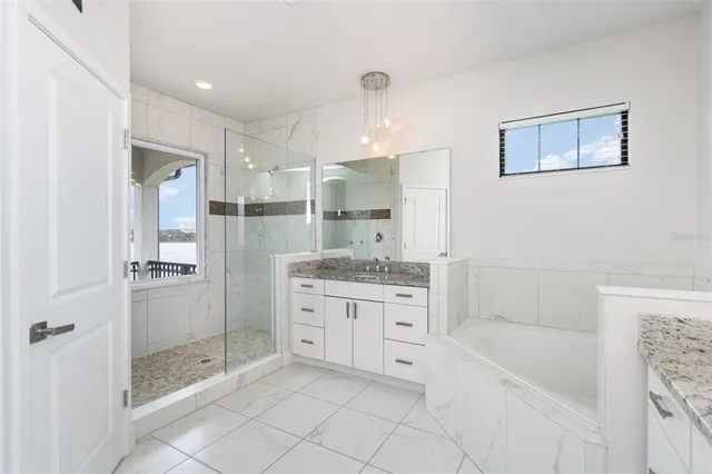a bathroom with a granite countertop bathtub shower sink and mirror