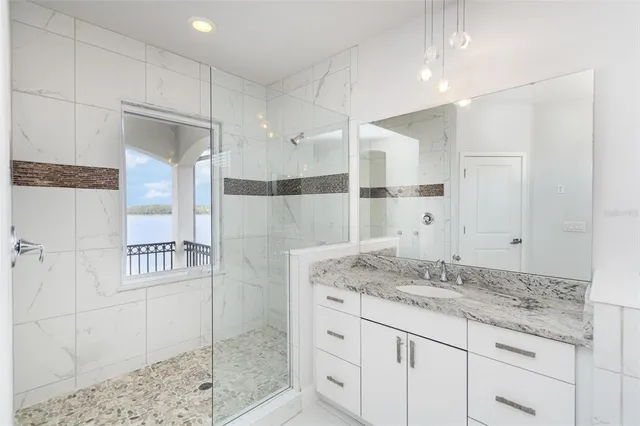 a bathroom with a granite countertop sink mirror and shower