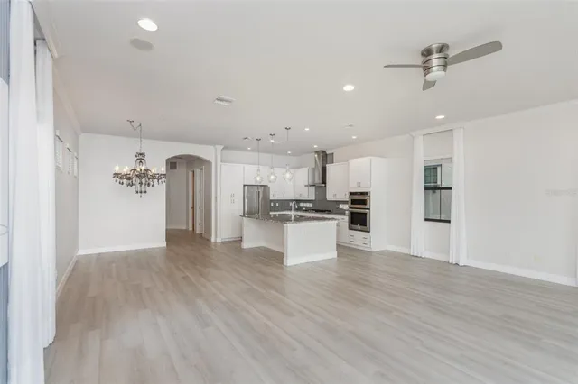 a view of kitchen with stainless steel appliances refrigerator stove and wooden floor