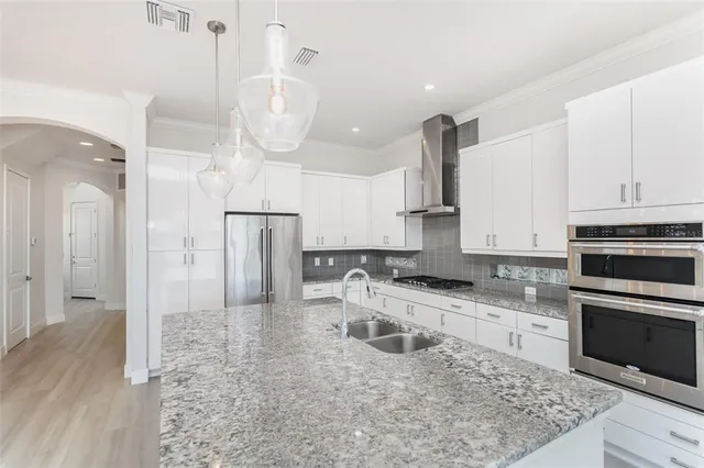 a kitchen with stainless steel appliances granite countertop a sink a stove and a refrigerator