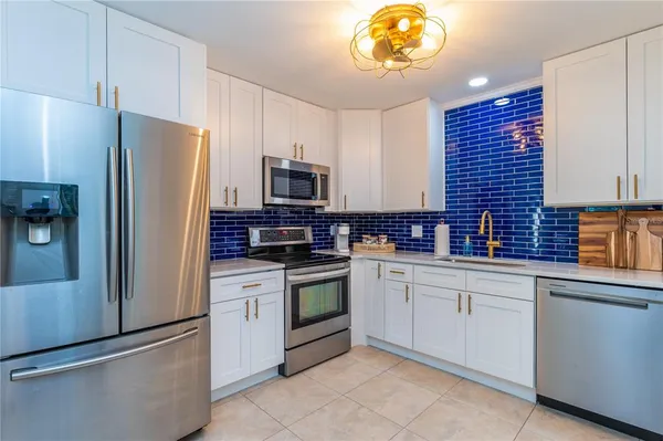 a kitchen with stainless steel appliances a refrigerator stove and microwave