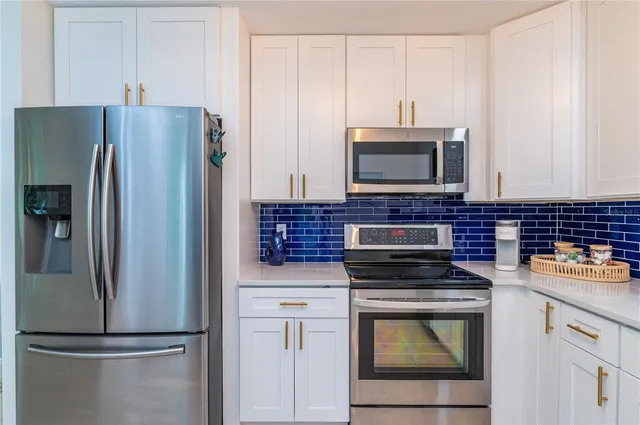 a kitchen with stainless steel appliances granite countertop a sink and a stove