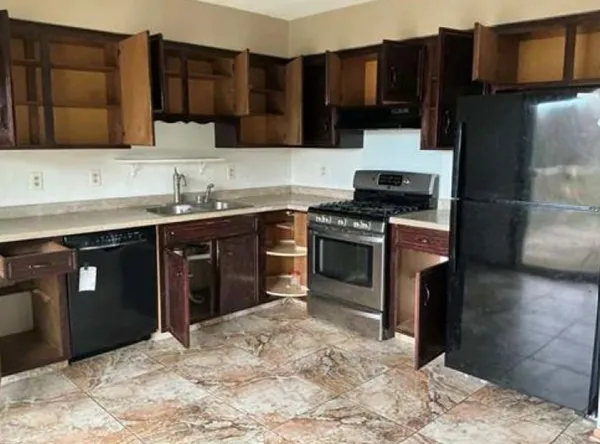 a kitchen with stainless steel appliances granite countertop a stove a sink and a refrigerator