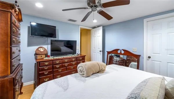 a bedroom with a bed and a flat tv screen on dresser