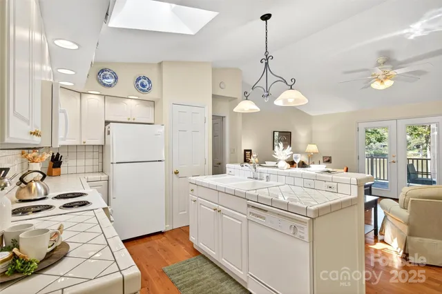 a view of a kitchen stove a refrigerator a sink dishwasher with a dining table and chairs