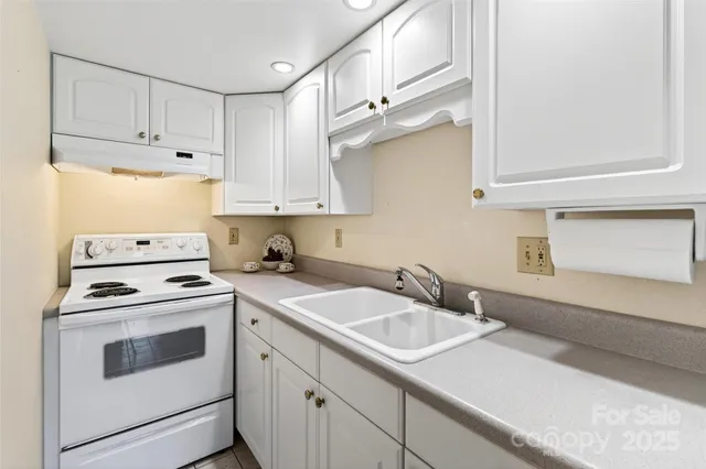 a kitchen with cabinets appliances a sink and a window