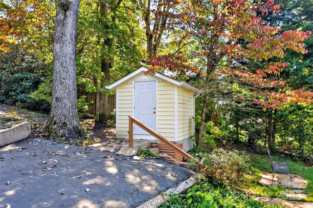 a view of a small house in middle of the forest