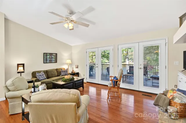 a living room with furniture and a large window with wooden floor