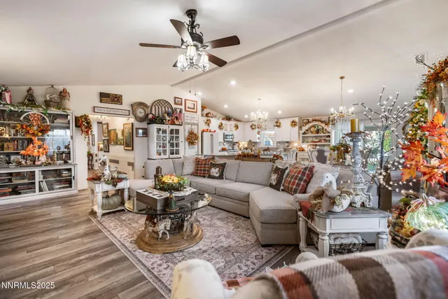 a living room with furniture kitchen view and a chandelier