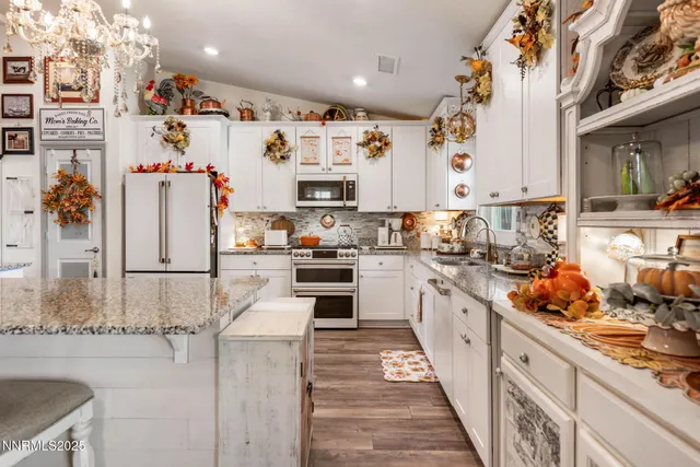 a kitchen with stainless steel appliances kitchen island granite countertop a refrigerator and a stove top oven
