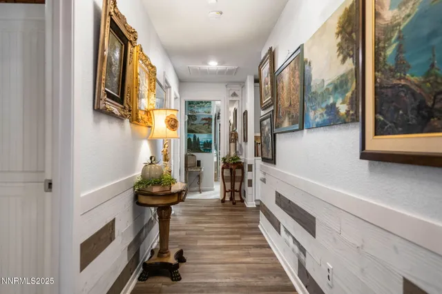 a view of a hallway with wooden floor and staircase