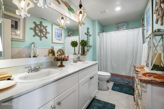 a bathroom with a double vanity sink toilet and a mirror