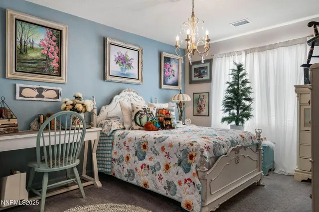 a bedroom with bed a chandelier and a window