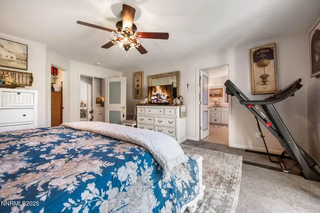 a bedroom with a bed and a large mirror on the dresser