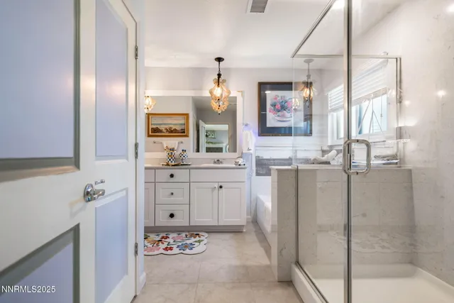 a spacious bathroom with a shower sink and mirror