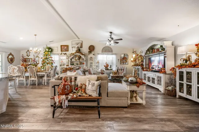 a living room with furniture kitchen view and a wooden floor
