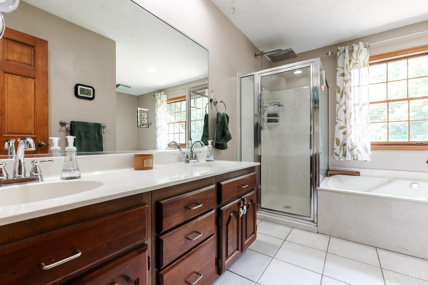 623 Ibold Road Loveland, OH 45140 - Photo 19 of 35 Completing the primary suite is a spacious ensuite bath featuring a double vanity, walk-in shower, relaxing jetted tub, and large window overlooking the backyard, creating a bright and inviting retreat.