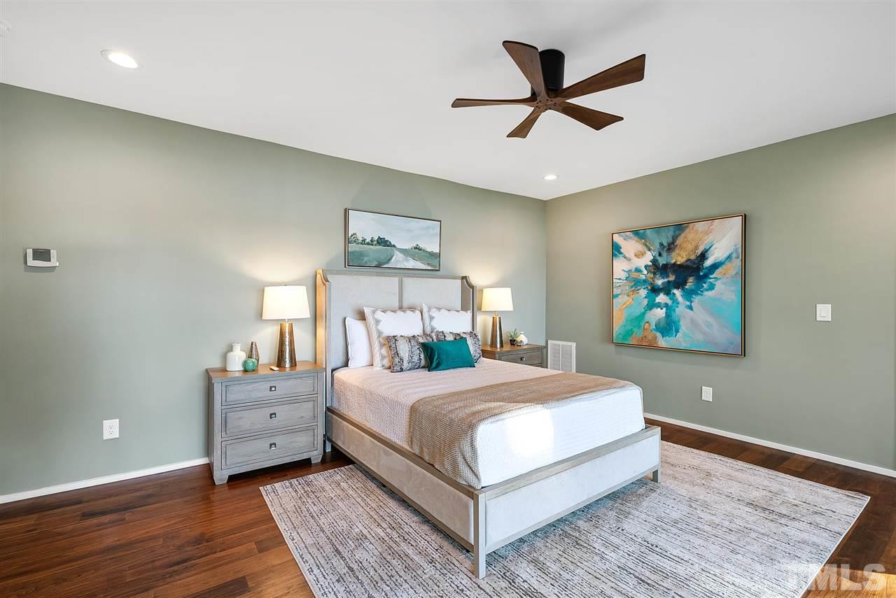 6900 Denlee Road Raleigh, NC 27603 - Photo 15 of 30 a bedroom with a large bed chandelier and a window