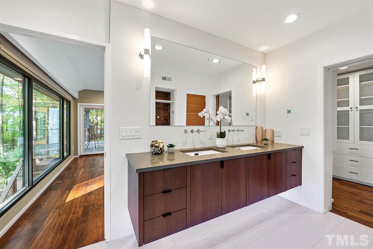 6900 Denlee Road Raleigh, NC 27603 - Photo 17 of 30 a spacious bathroom with a double vanity sink a large mirror and shower