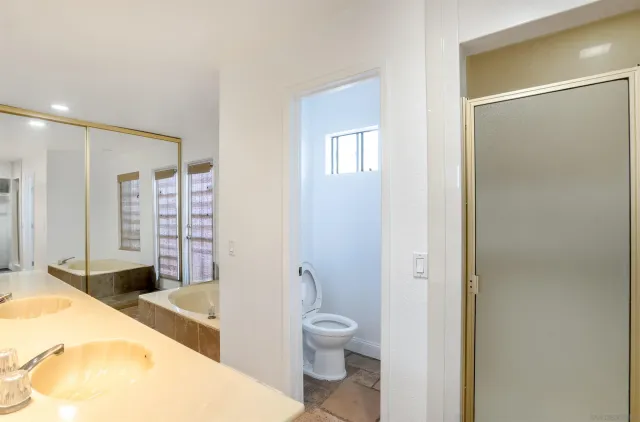 a spacious bathroom with a granite countertop sink toilet and shower