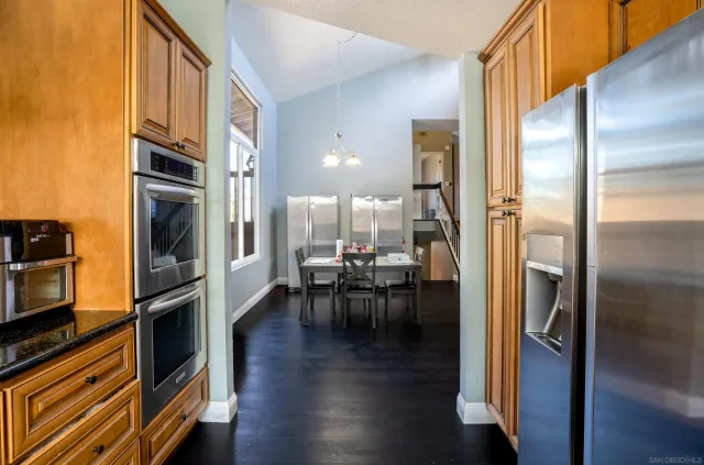 a kitchen with stainless steel appliances granite countertop a refrigerator and a stove top oven