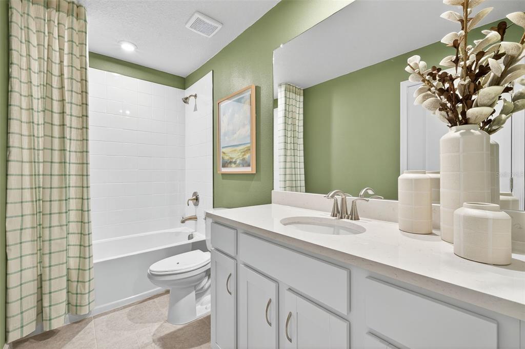 8838 Ginko Run Parrish, FL 34219 - Photo 14 of 21 a bathroom with a granite countertop sink a toilet and shower