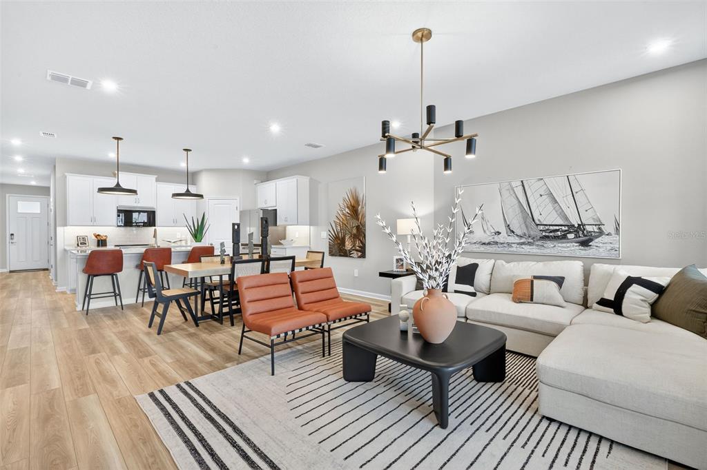 8838 Ginko Run Parrish, FL 34219 - Photo 6 of 21 a living room with lots of furniture and a chandelier