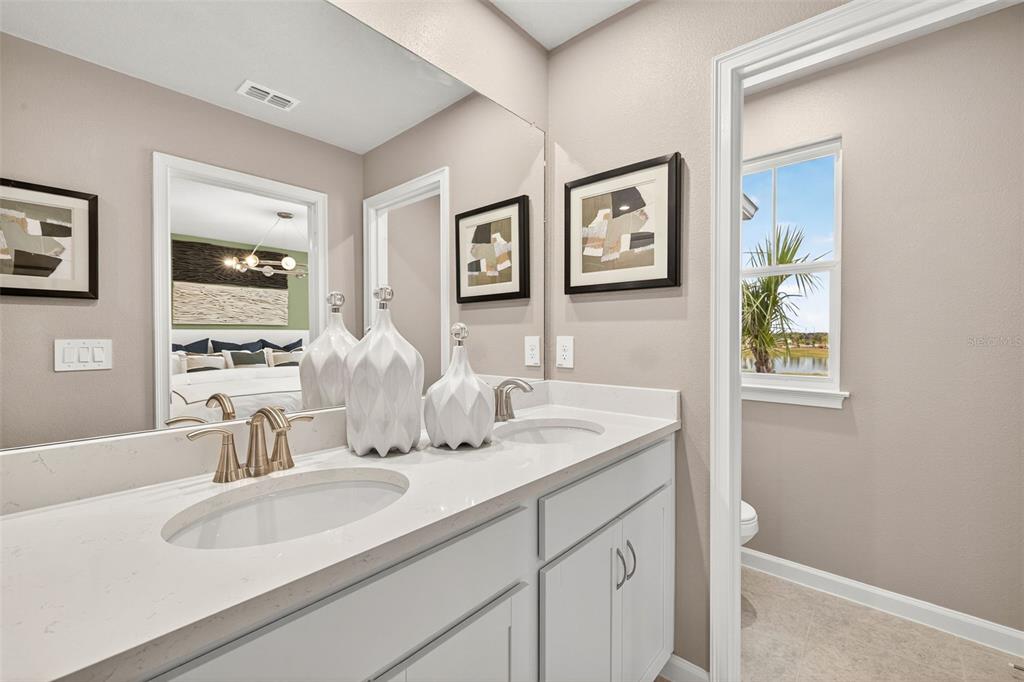 8838 Ginko Run Parrish, FL 34219 - Photo 10 of 21 a bathroom with a double vanity sink and a mirror