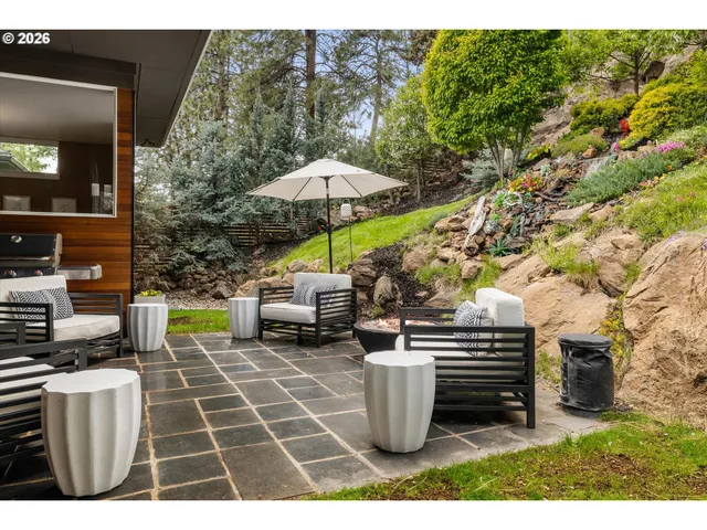 a couple of chairs sitting in a backyard of a house