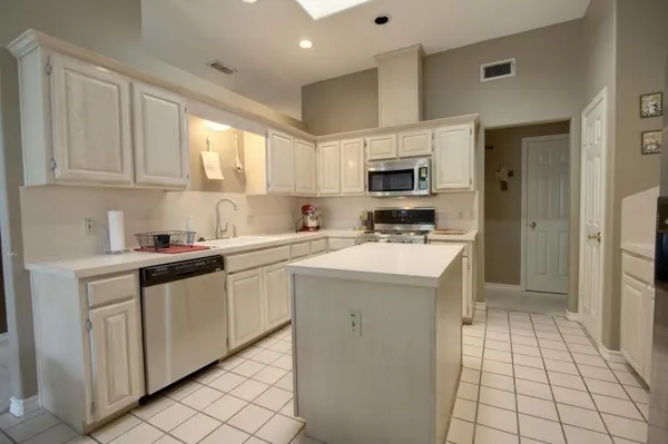 a kitchen with cabinets appliances a sink and a counter top space