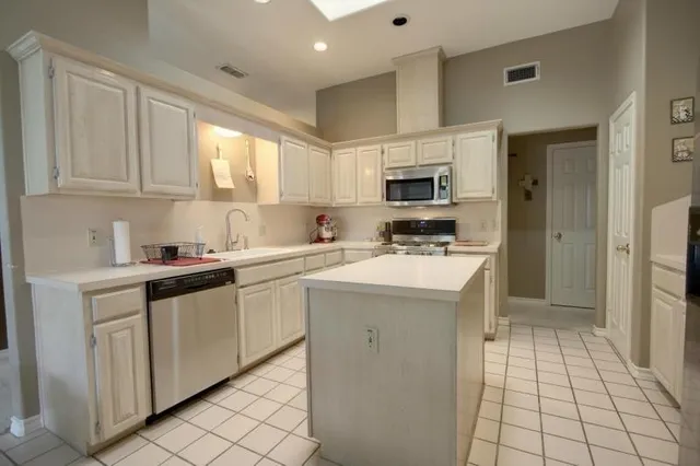 a kitchen with cabinets appliances a sink and a counter top space