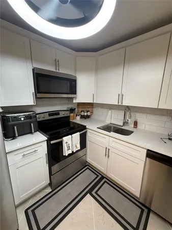 a kitchen with a sink and white cabinets