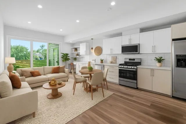 a living room with furniture a large window and a kitchen view