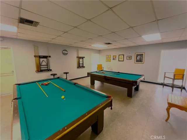 a room with pool table and windows