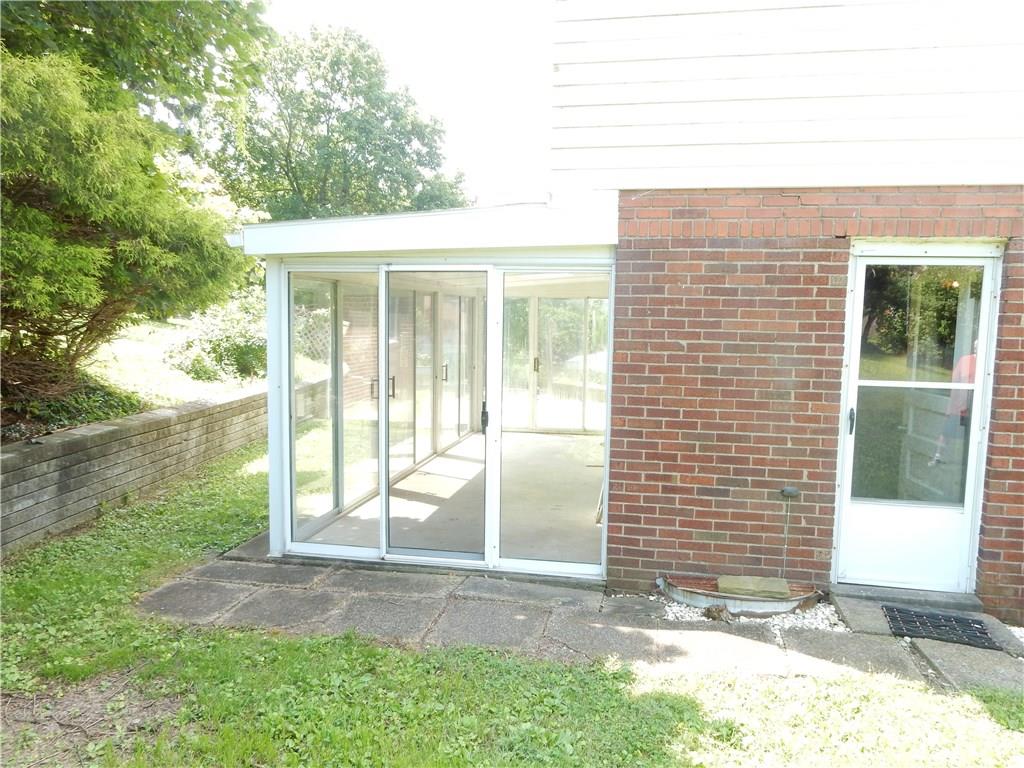 3719 Schuette Road Pittsburgh, PA 15227 - Photo 19 of 24 A side view of the home with entry to the kitchen on the right and the sun room straight ahead. The back yard ends right above the back wall, along the fence line.