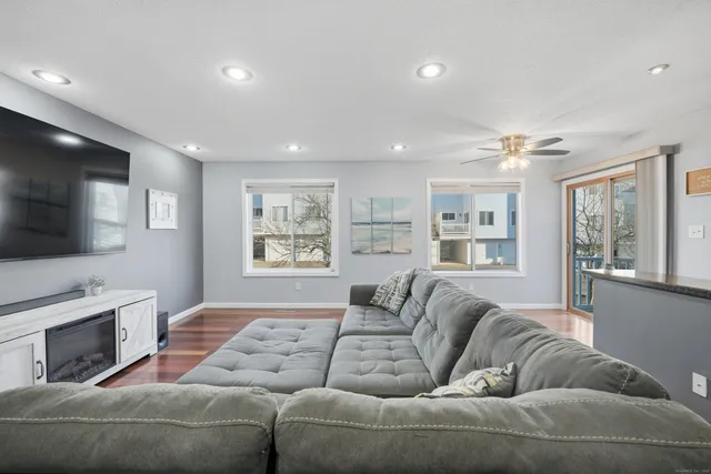 a living room with furniture a flat screen tv and a fireplace
