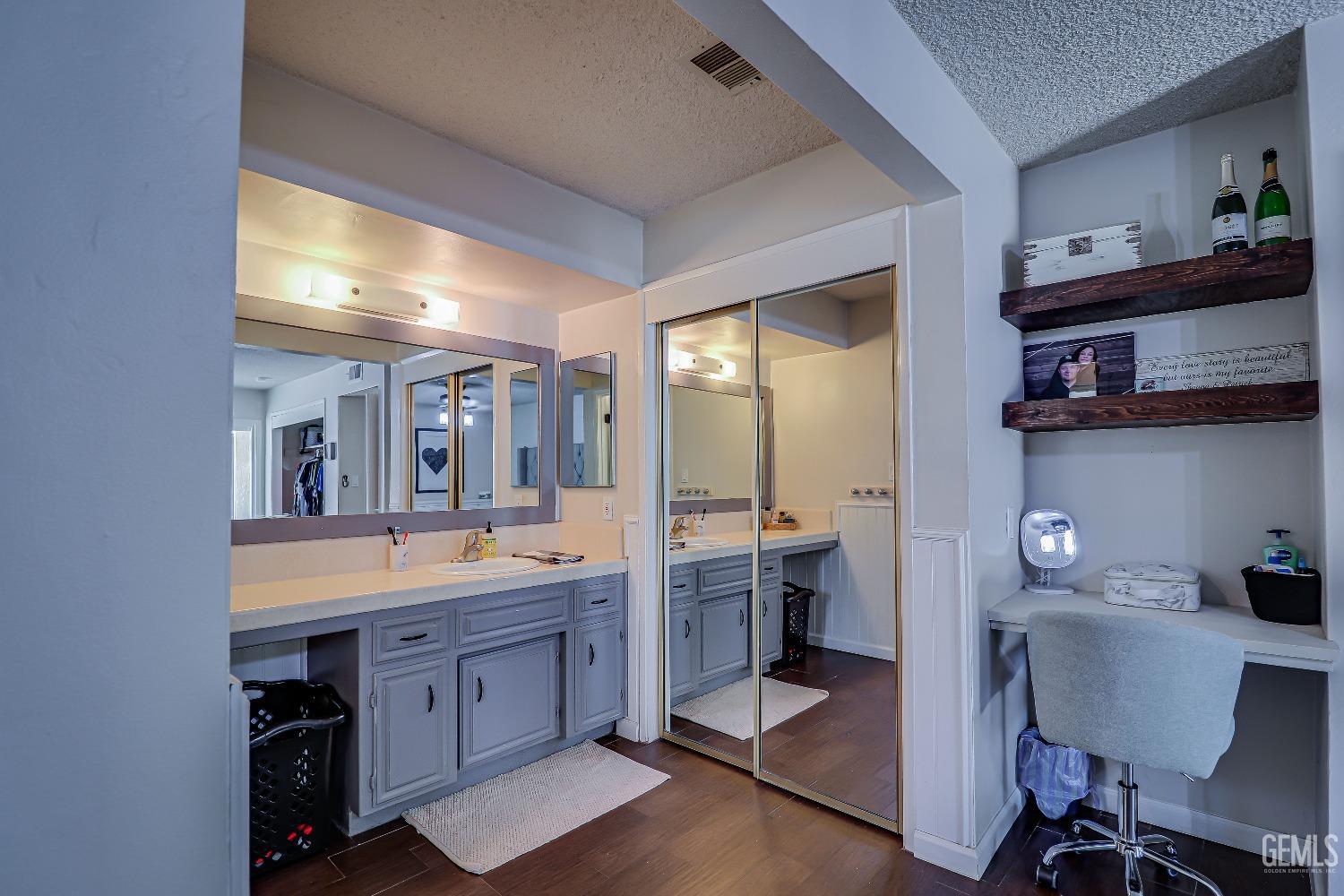 Undisclosed Address Bakersfield, CA 93308 - Photo 30 of 38 a spacious bathroom with a double vanity sink and a mirror